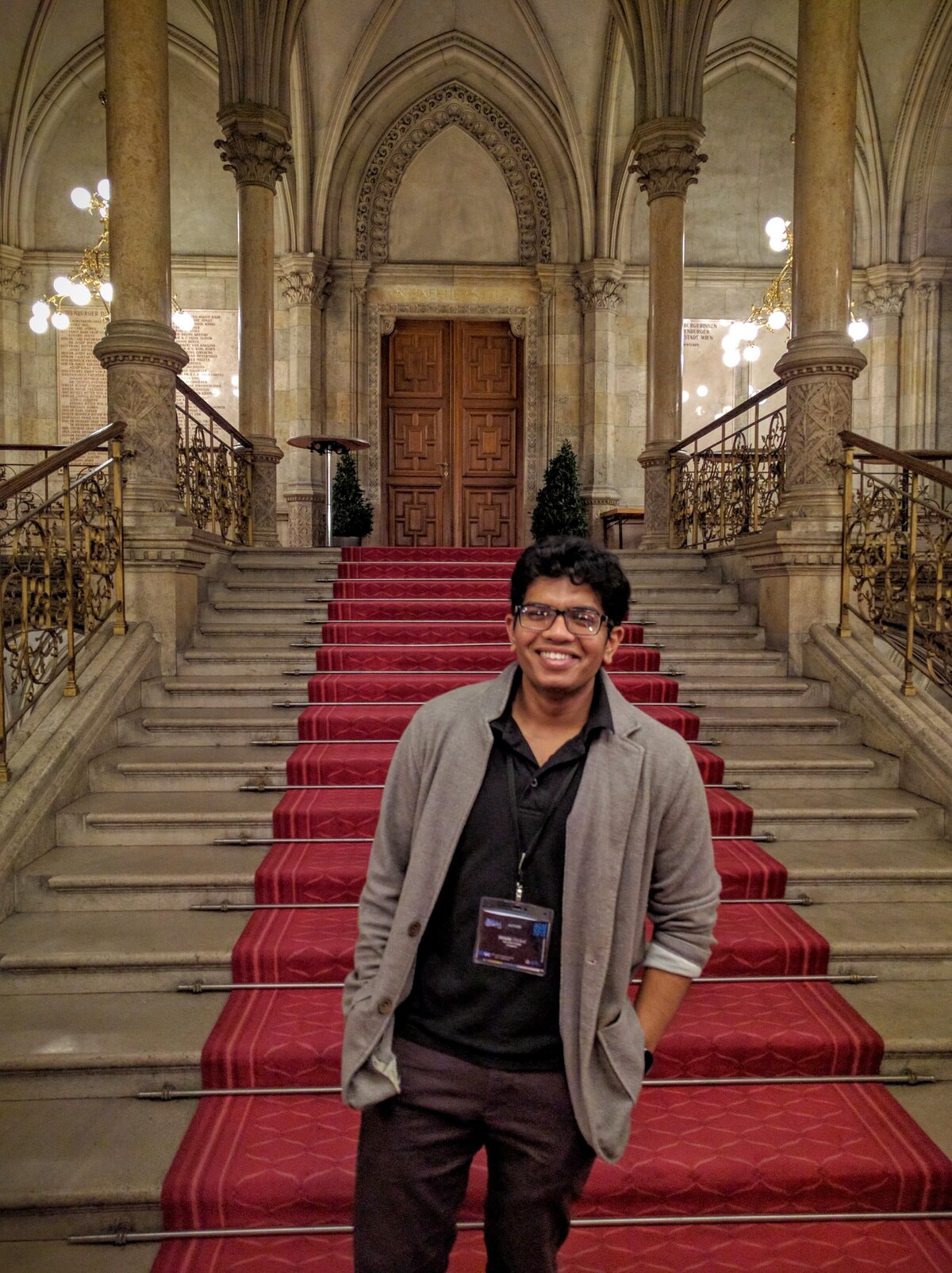 Hrishi at the staircase of the ACM CCS 2016 venue in Vienna, with conference badge.